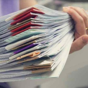Stack of paper documents being scanned for digital archiving and preservation