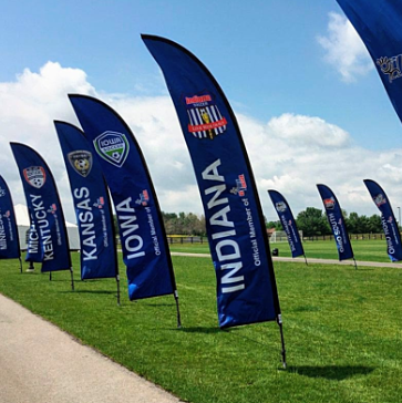 Feather flag waving outside business with vertical branding