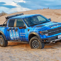 Full-color vehicle graphics applied to car side panels for branded fleet marketing